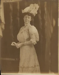 Mme Lon Stephens, née Margaret Nelson. Portant une robe à col montant en dentelle et un chapeau à plumes